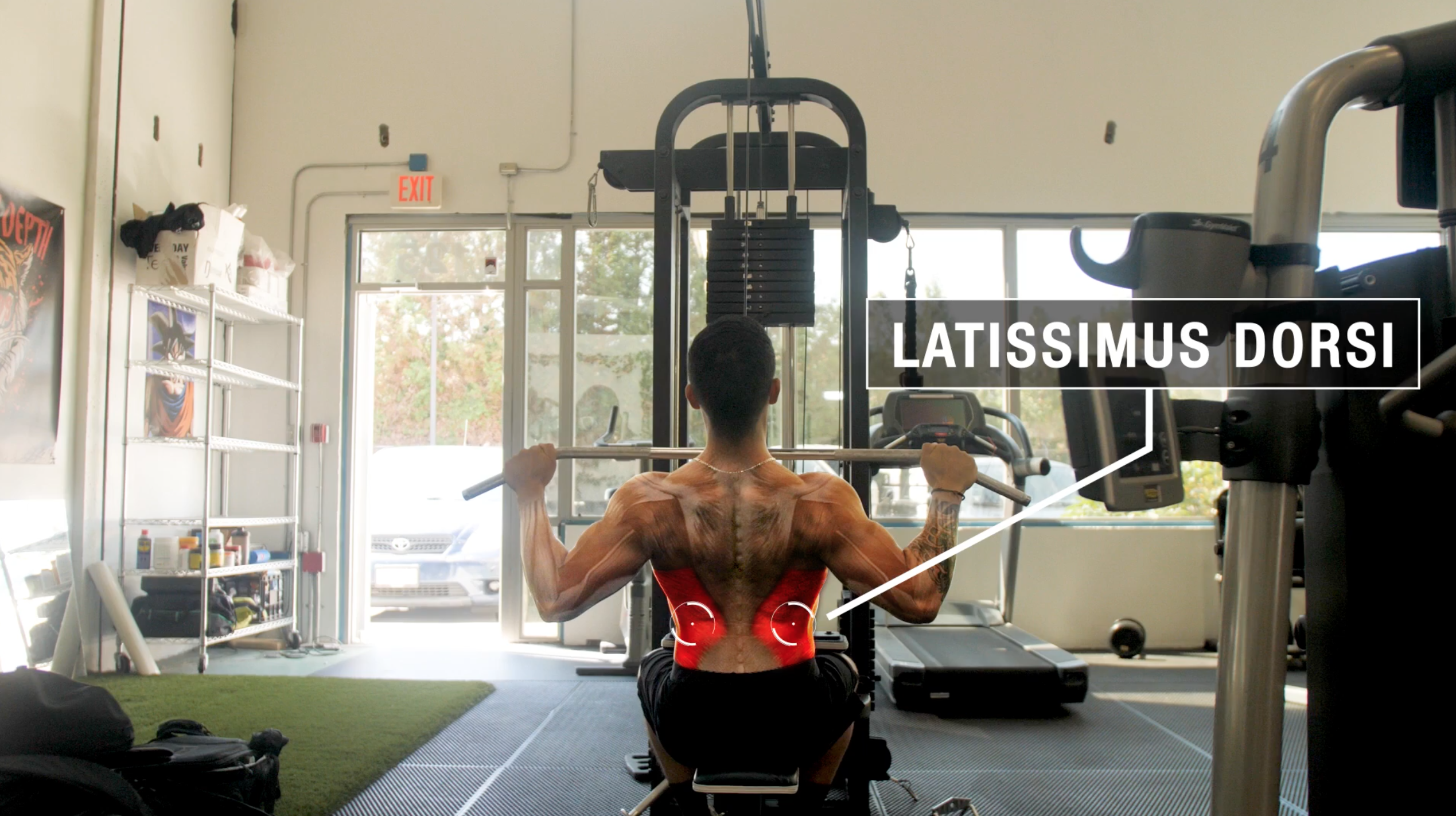 Fit female doing rear lat pull-down under supervision of her